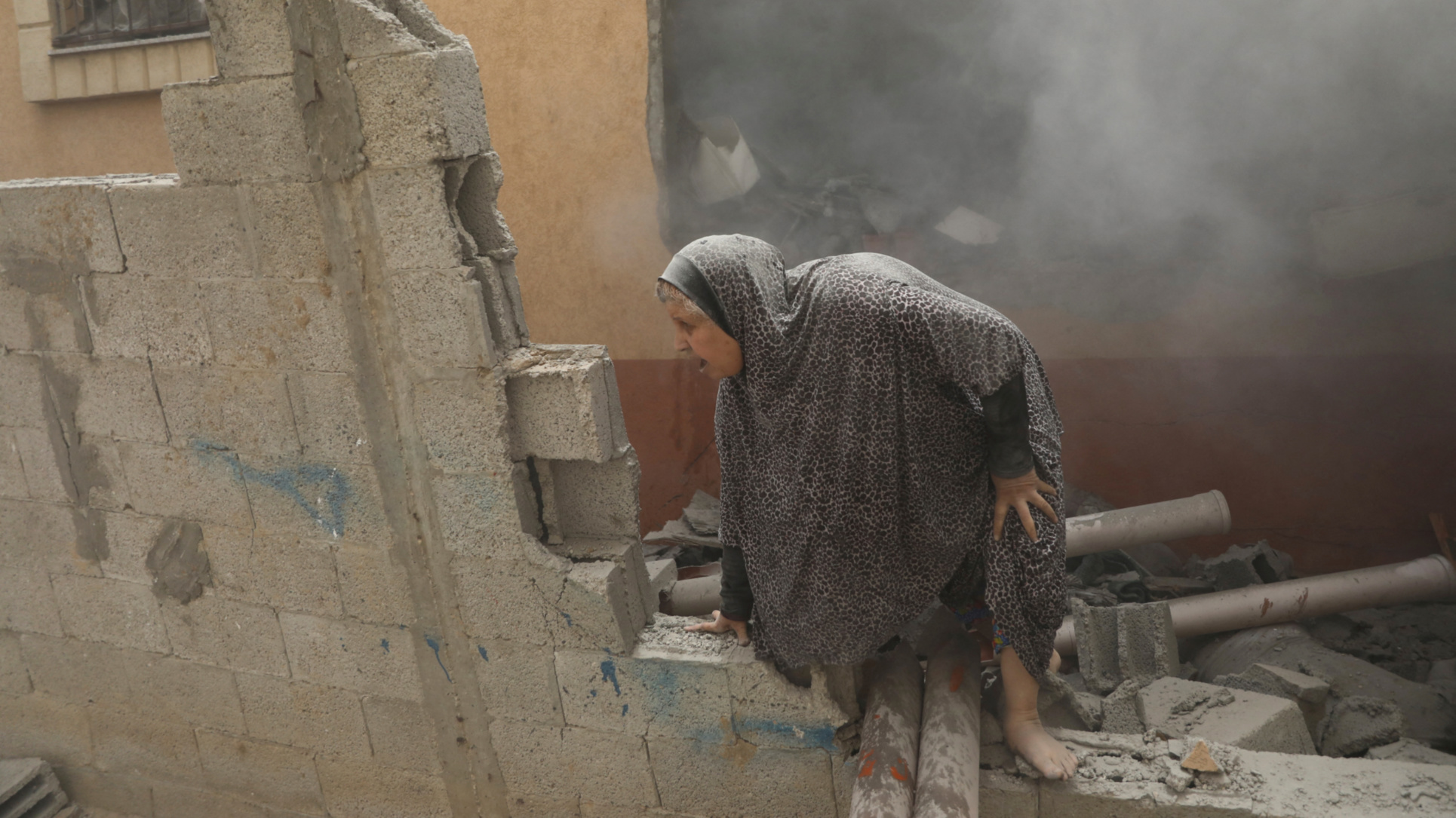 A Palestinian woman reacts at the site of an Israeli strike on Deir al-Balah, central Gaza Strip on 14 June 2024 (Reuters/Abed Khaled)