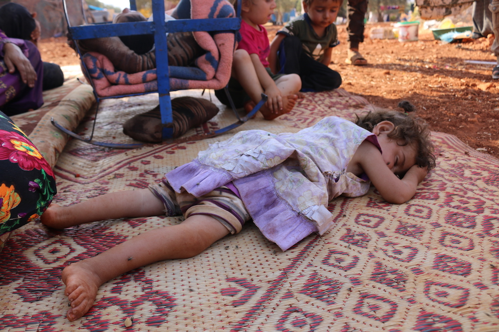 Une fillette dort sur une natte dans le camp de réfugiés de la région d’Idleb (MEE/Mustafa Dahnon)