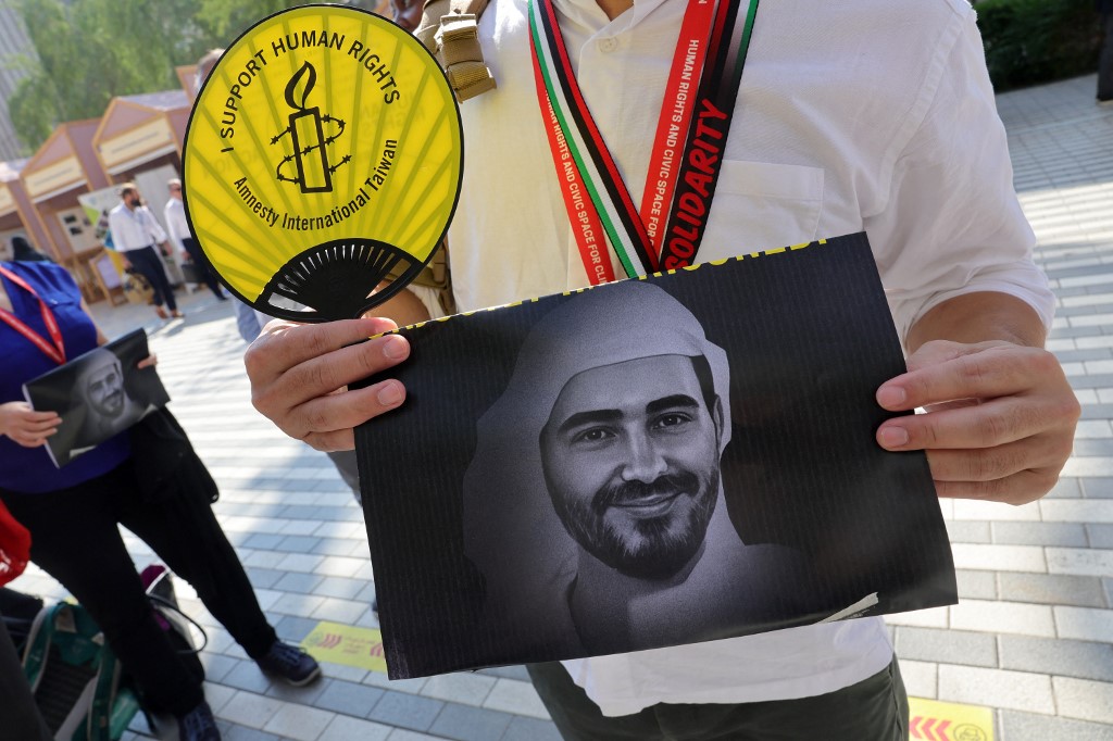 An Amnesty International activist holds a portrait of imprisoned UAE democracy advocate Mohammed al-Sidiq at the Cop28 summit in Dubai on 9 December 2023 (AFP)