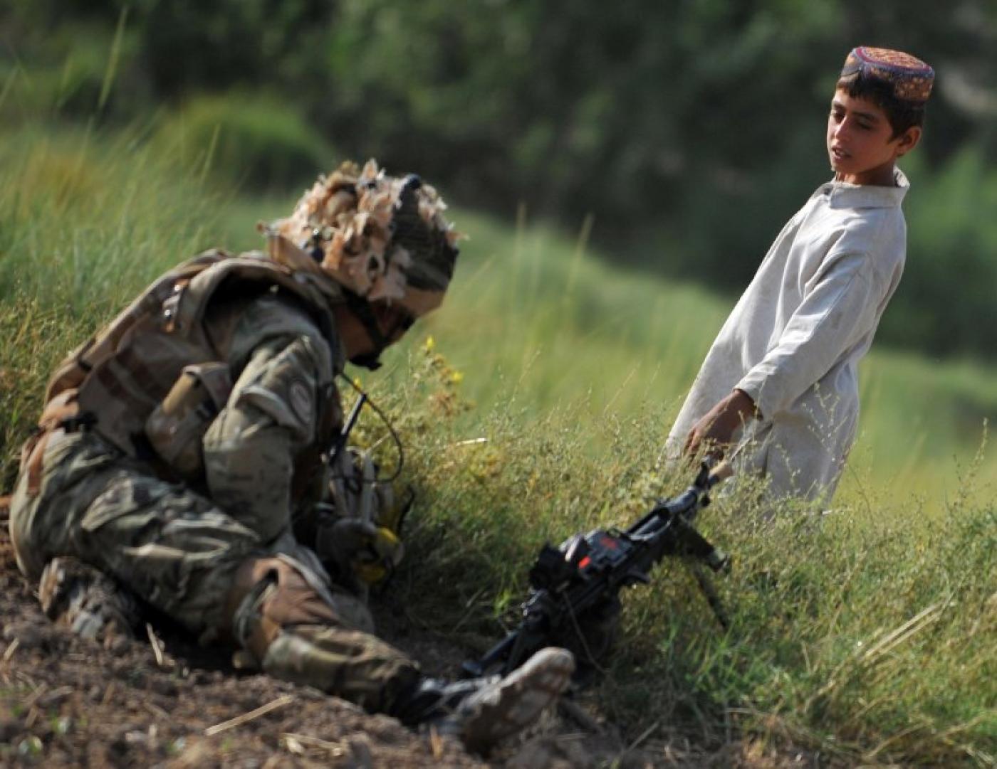 Un jeune Afghan regarde un soldat du 1er bataillon de The Rifles à Nahr-e Saraj, dans la province de Helmand, en juin 2010 (AFP)
