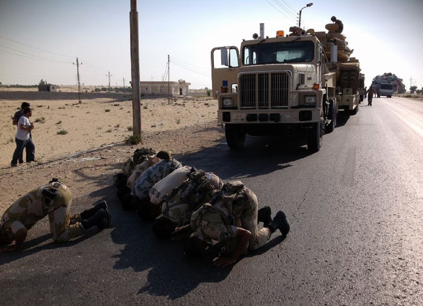Des soldats égyptiens prient alors qu’ils sont déployés dans la ville d’El-Arish, dans le nord du Sinaï, en 2013 (AFP)