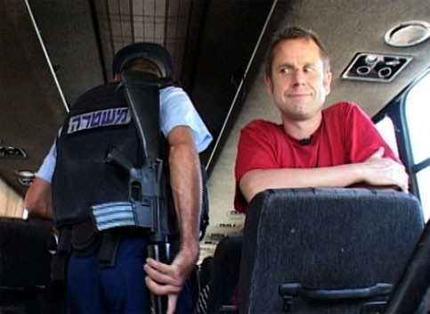 Jeremy Hardy on a coach being searched by Israeli police (screenshot)