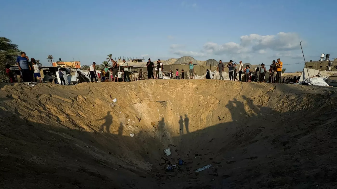 Palestinians inspect the site following Israeli strikes on a refugee camp in al-Mawasi, southern Gaza, on 10 September 2024 (Mohammed Salem/Reuters)