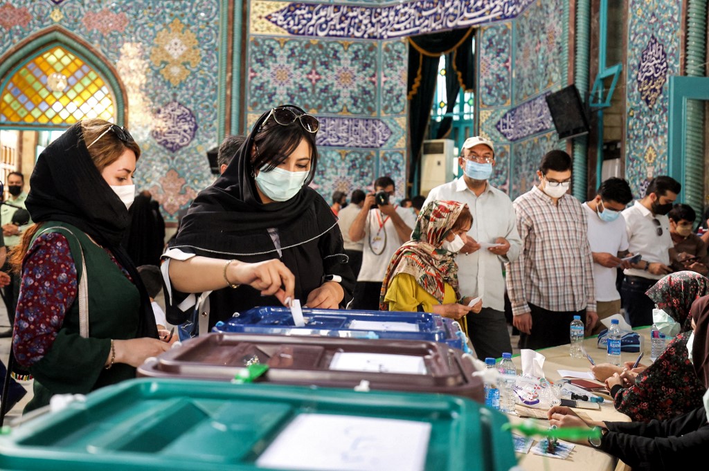 Iranians vote at a polling station in Tehran on 18 June 2021 (AFP)