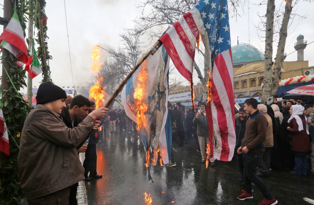 Iranians burn Israeli and US flags in Tehran in February 2019 (AFP)
