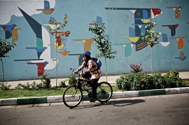 An Iranian woman rides her bicycle in a southwestern street of Tehran on June 29, 2015