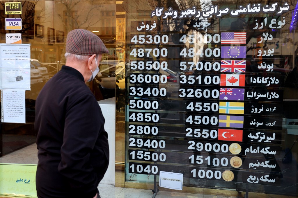 A man looks at currency exchange rates an exchange shop in Tehran on February 21, 2023.
