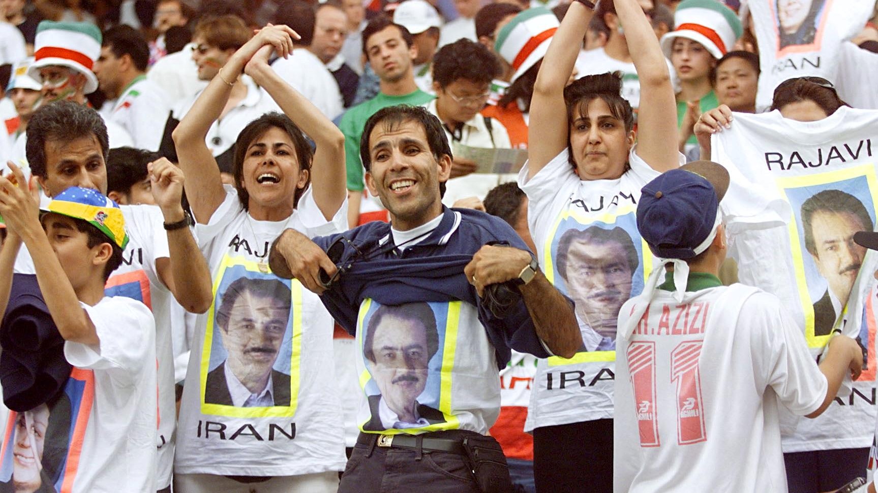 Supporters display portraits of the leader of the Mujahedin-e-Khalq (MeK) organisation at the match between Iran and the United States on 21 June, 1998 (AFP)