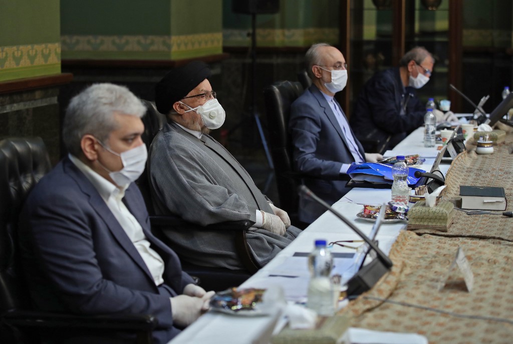 Iranian cabinet members wear protective masks during a session in Tehran on 25 March (Iranian Presidency/AFP)