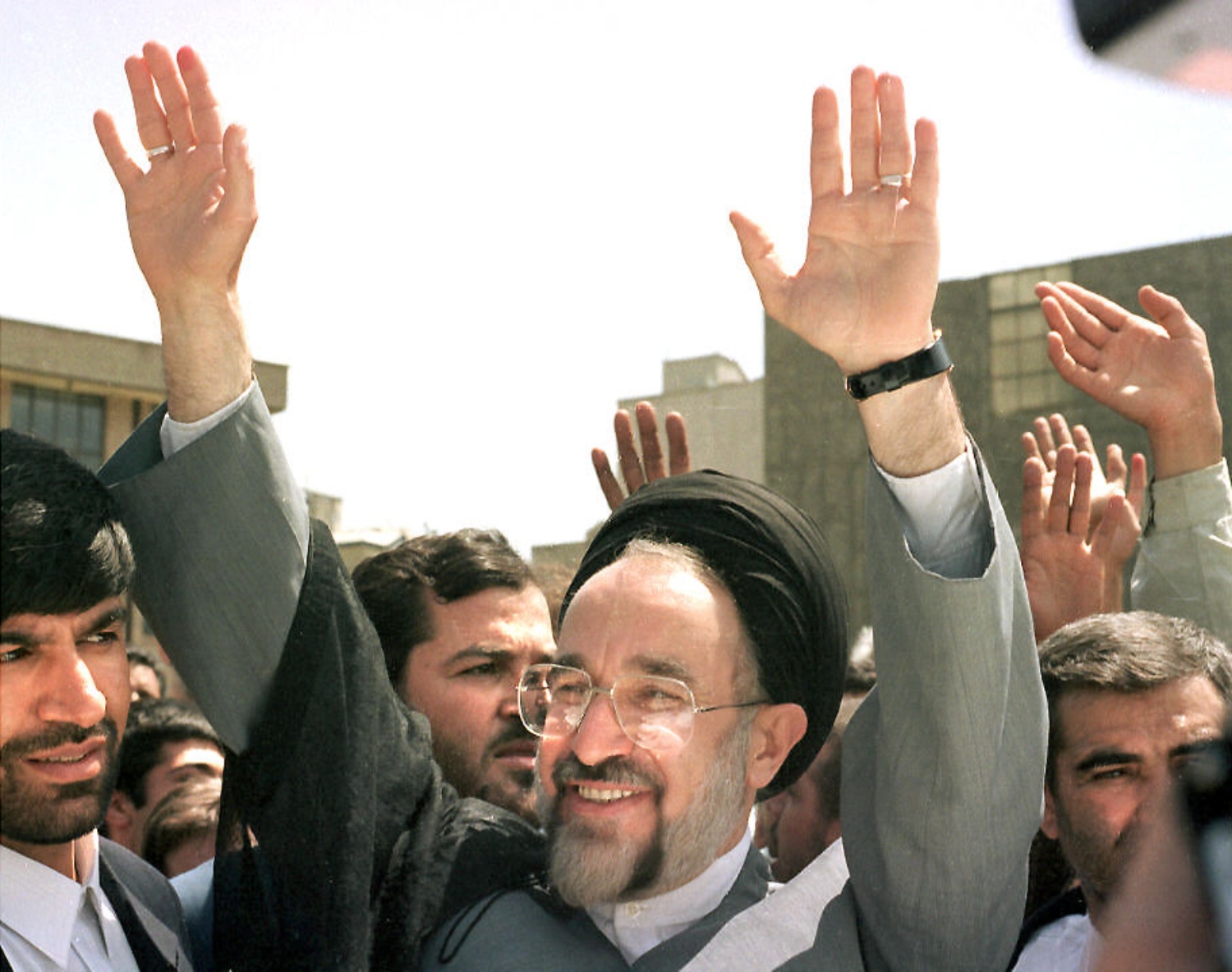 Reformist presidential candidate Mohammed Khatami waves at a crowd of supporters outside of a polling station on 23 May 1997 (AFP)