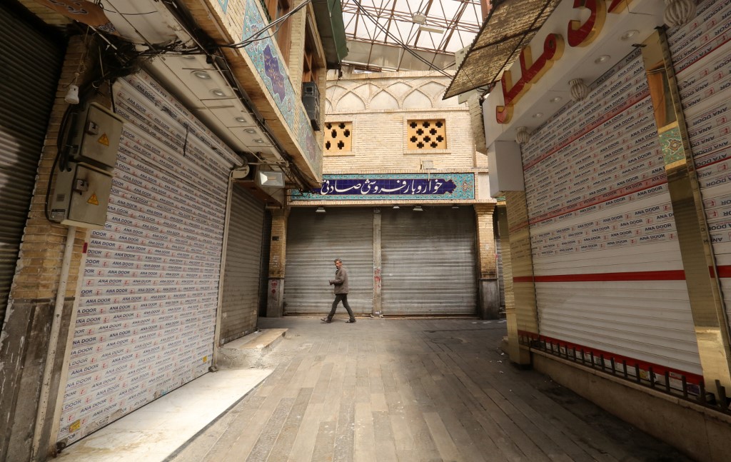 A lone Iranian man walks through a closed indoor market in Tehran on 5 April (AFP)