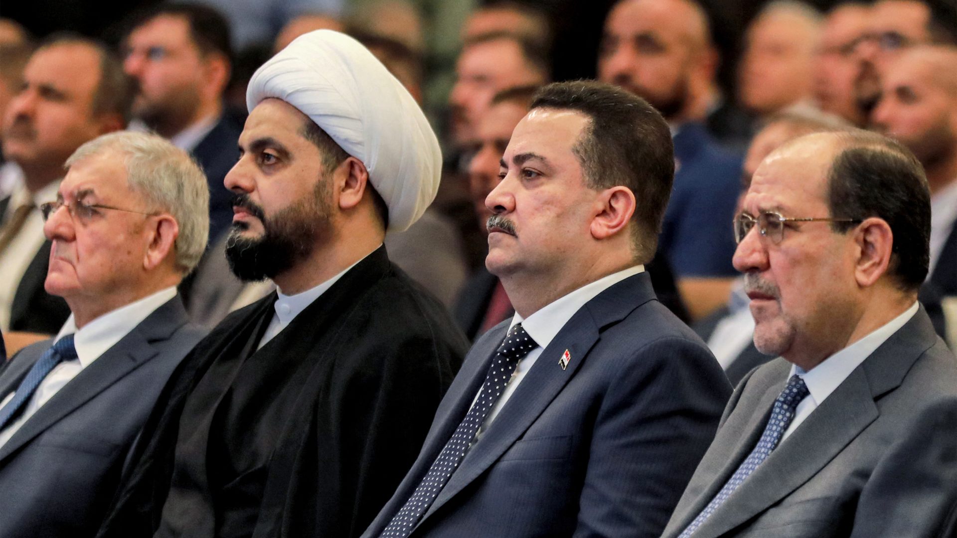 Iraqi Prime Minister Mohammed Shia al-Sudani (2nd R), flanked by Asaib Ahl al-Haq leader Qais Khazali (2nd L) and former prime minister Nouri al-Maliki at an event in May 2024 (Murtaja Latteef/AFP)