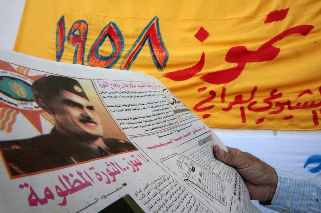 An Iraqi reads the communist party newspaper, 14 July 2007 in Baghdad, bearing a front page picture of General Abd al-Karim Qassim during a ceremony to commemorate the 1958 coup. 