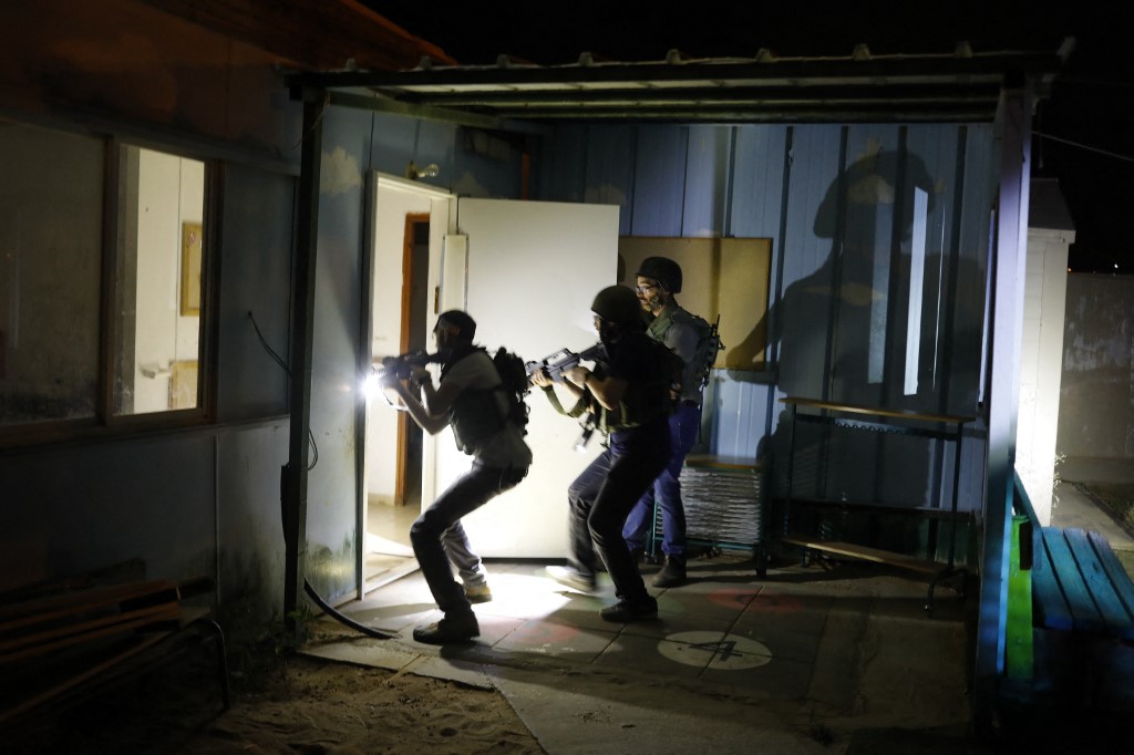 Israeli soldiers and settlers search houses in a West Bank settlement during an all-night army drill in 2018 (AFP)