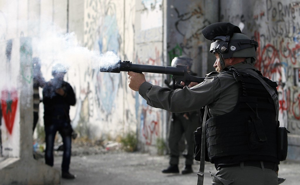 An Israeli border guard fires tear gas towards Palestinians in Bethlehem in 2017 (AFP)