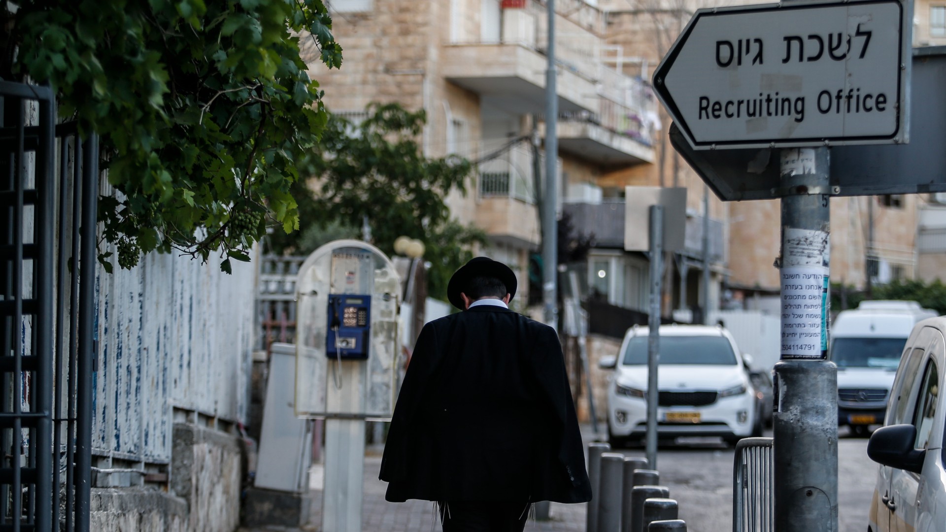 An ultra-Orthodox Jewish man standing at the Israeli army recruitment office in Jerusalem on 25 June (Reuters/Saeed Qaq/NurPhoto)