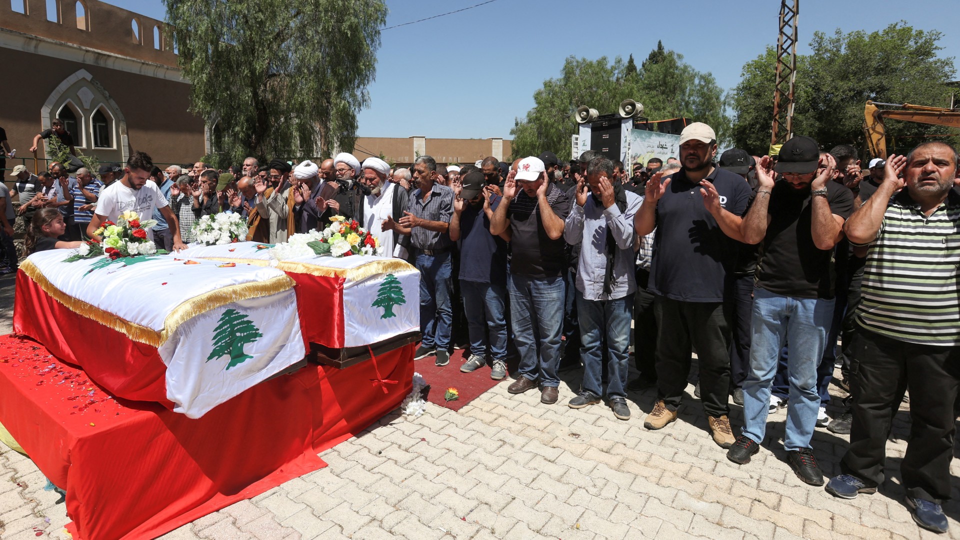 People pray during the funeral of the two brothers who were killed by an Israeli strike yesterday, in Lebanon's Houla village near the border with Israel, 3 June (Reuters/Aziz Taher)