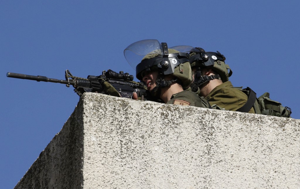 Israeli troops aim towards Palestinian protesters in the occupied West Bank in 2019 (AFP)