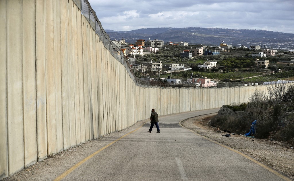 A man walks by Israel’s separation wall on 1 February (AFP)