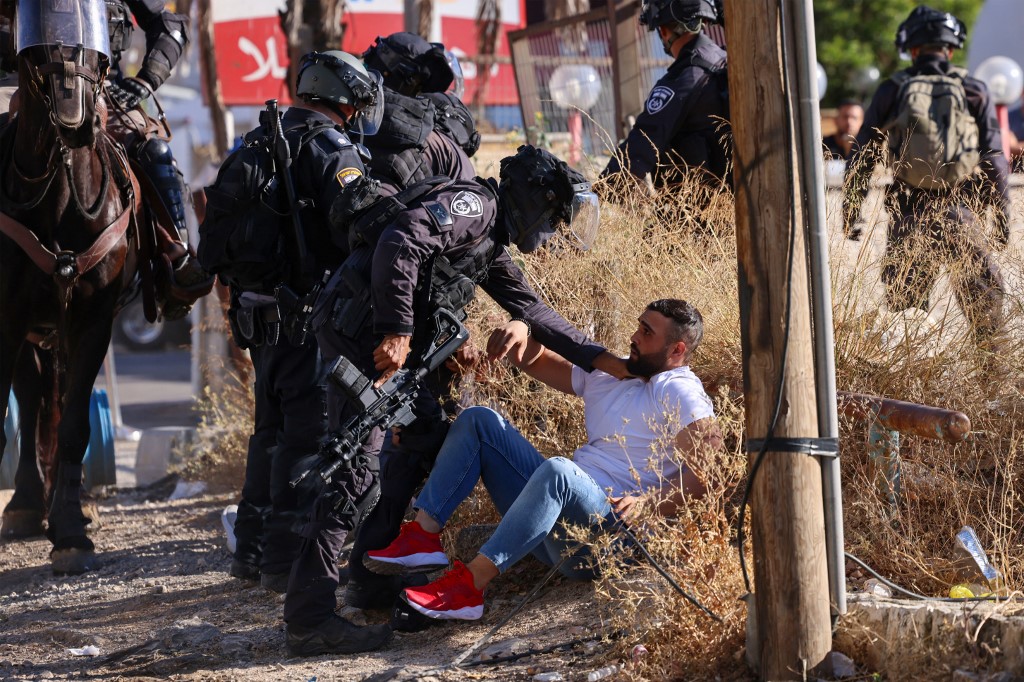 Israeli border police detain a Palestinian man during protests in the Sheikh Jarrah neighbourhood of occupied East Jerusalem on 18 May 2021 (AFP)
