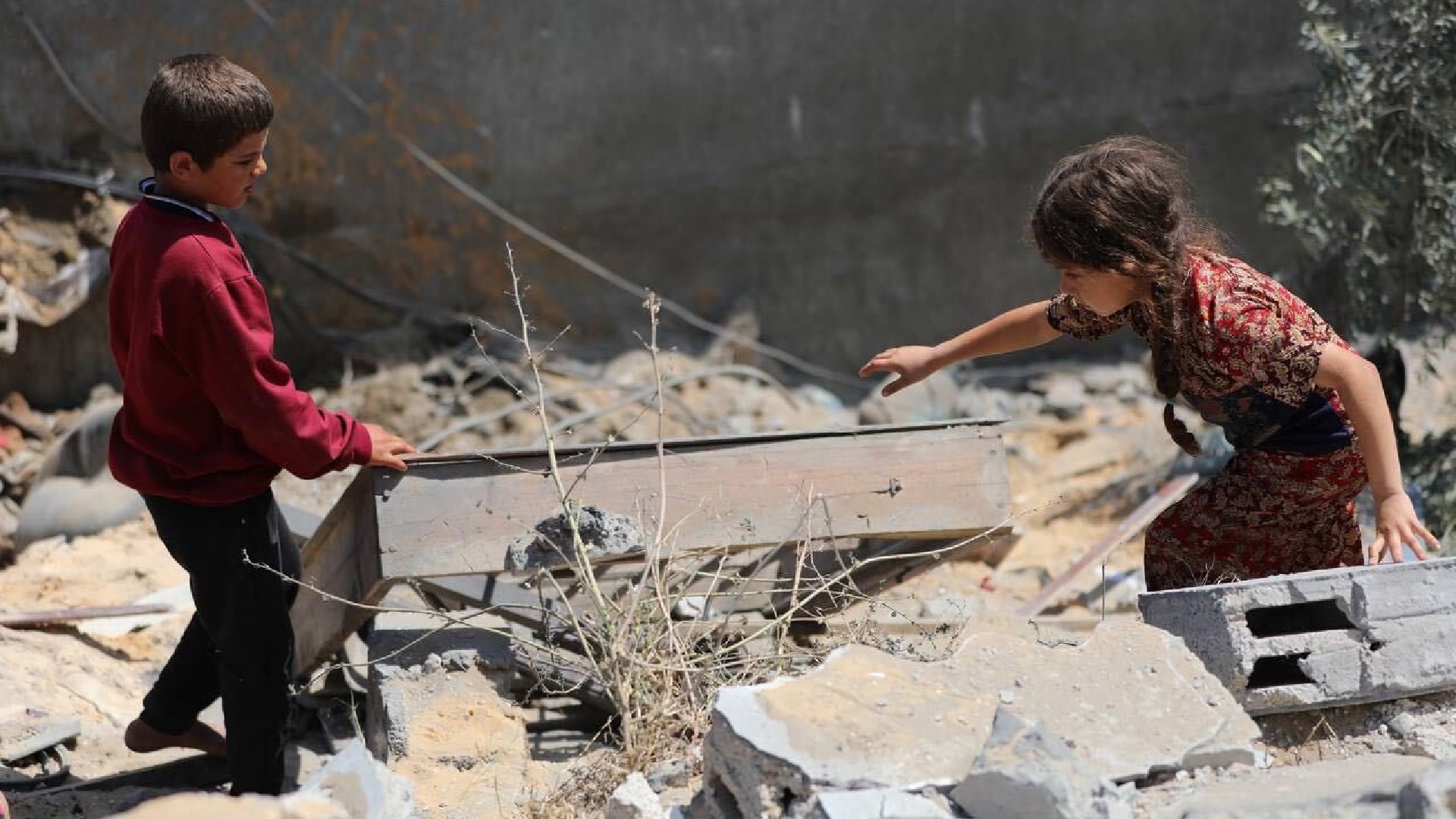 Palestinian children look through the rubble of their destroyed home in Beit Lahia in northern Gaza after it was bombed by Israeli air strikes on 13 May 2023 (MEE/Mohammed al-Hajjar)