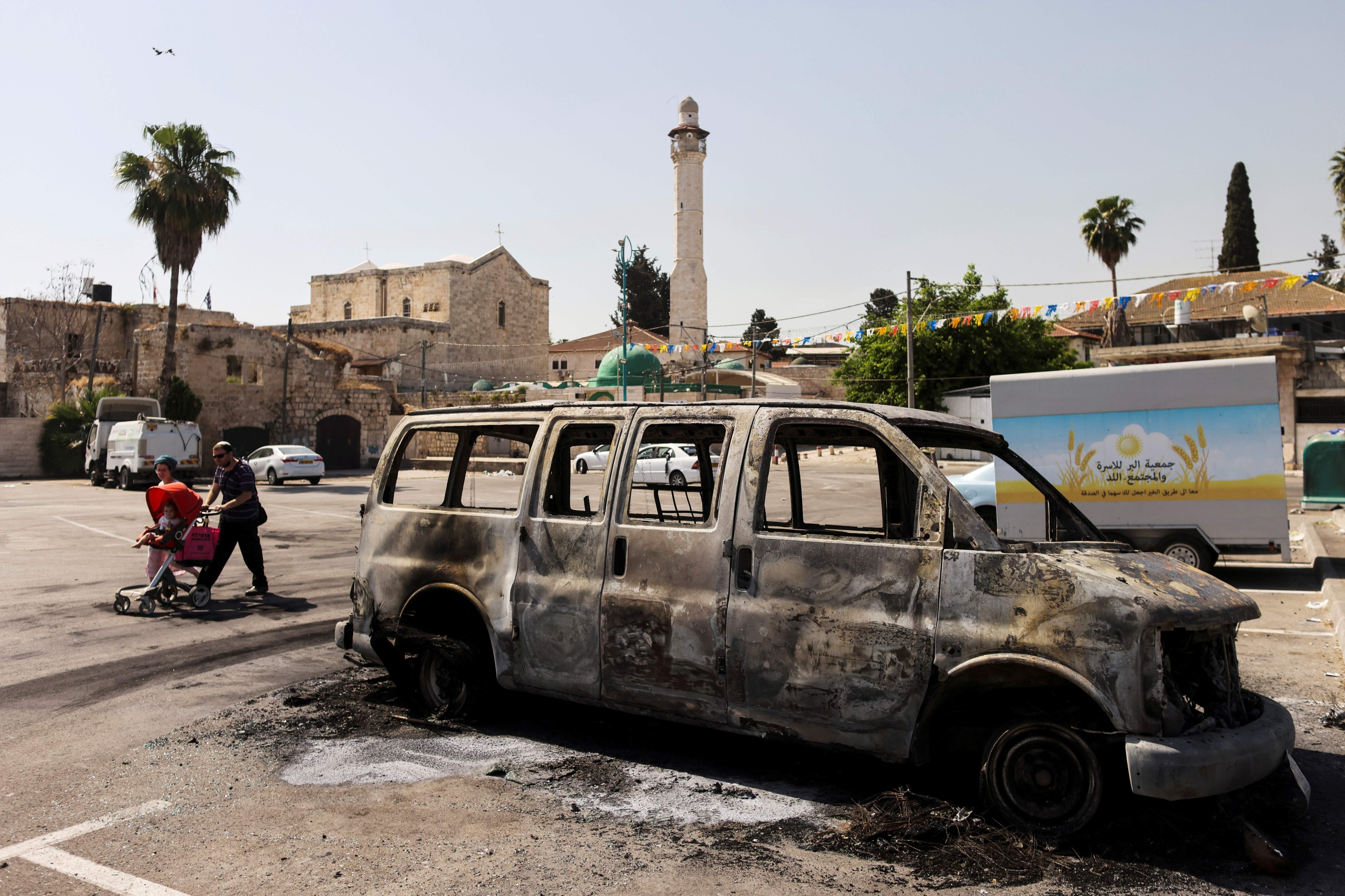 A burnt vehicle is seen outside the Omari Mosque in Lydd after violent riots in 12 May 2021 (Reuters)