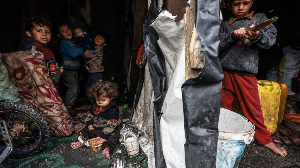 Des Palestiniens déplacés sont photographiés dans une tente de fortune dans un camp à Rafah, bande de Gaza, le 13 mars 2024 (Mohammed Abed/AFP)