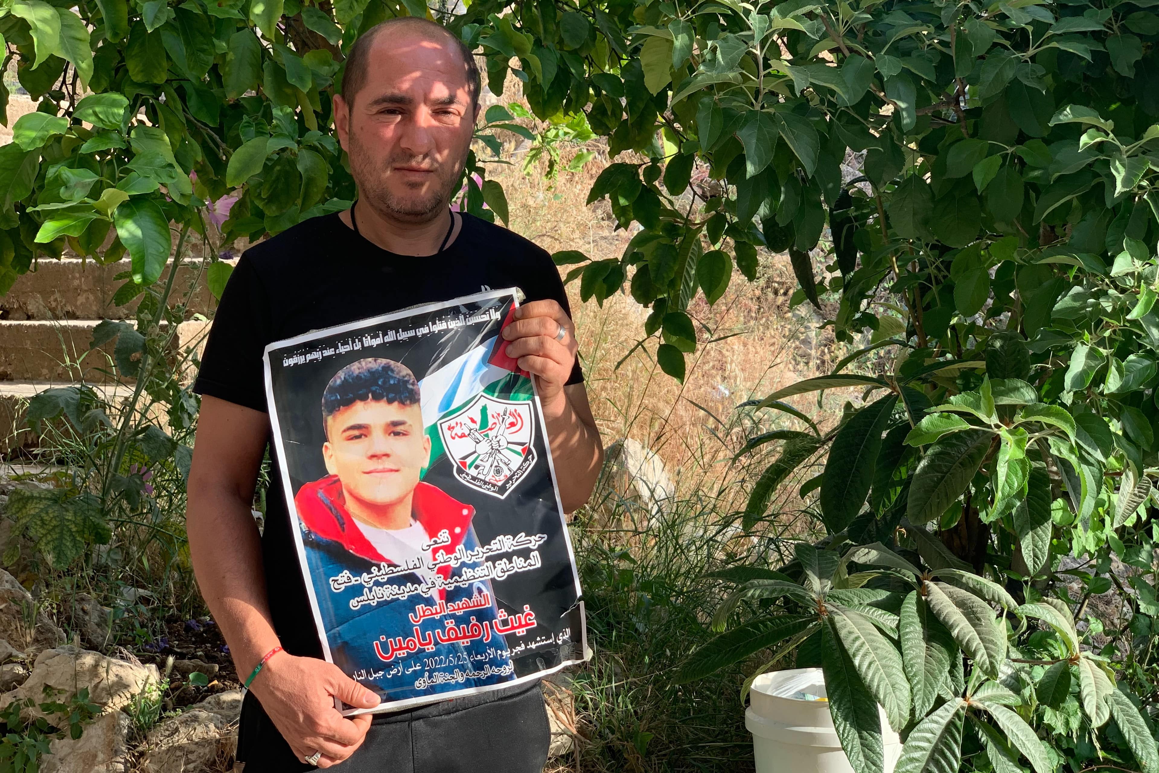 Rafiq Yamin holds a poster of his slain son Gaith, 16, at his home in Nablus in the occupied West Bank. (MEE/ Shatha Hammad)