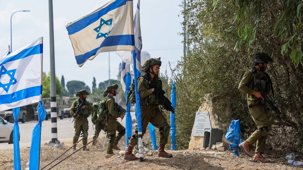 Des soldats israéliens patrouillent dans une zone de Kfar Aza, dans le sud d’Israël, près de la bande de Gaza, le 10 octobre 2023 (AFP)