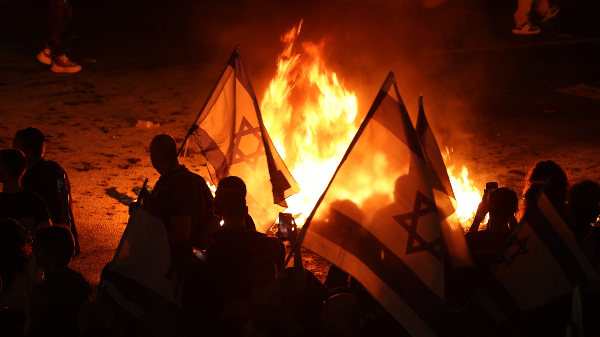 Protesters lightt a fire as they block a road in Tel Aviv after the dismissal of defence minister Yoav Gallant (Jack Guez/AFP)