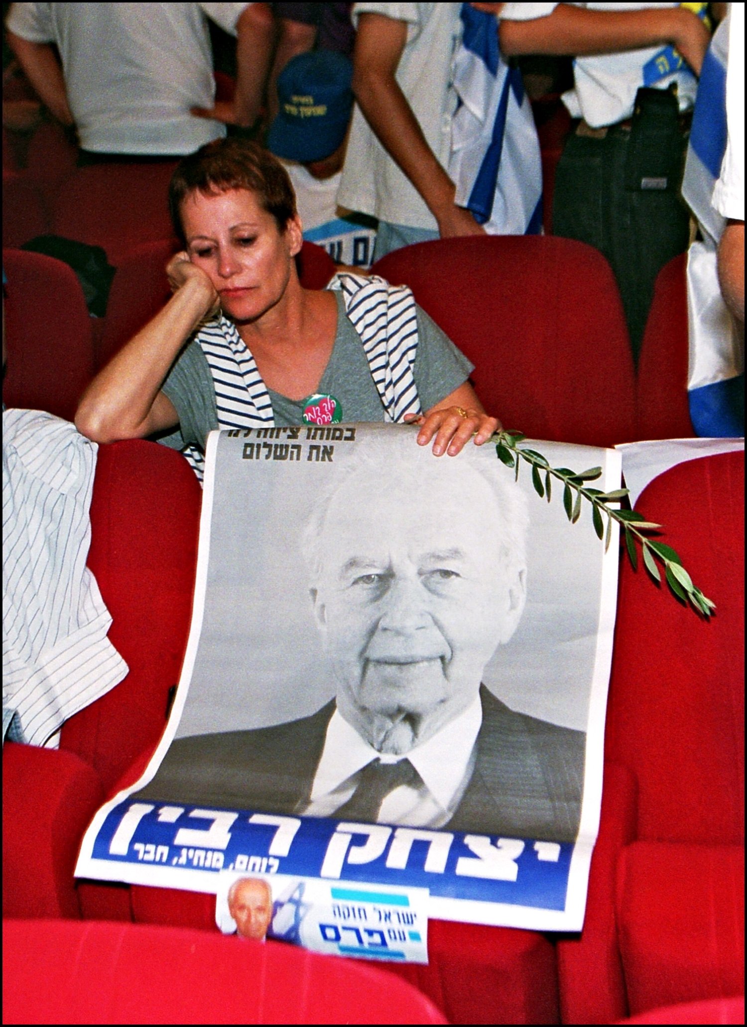 A Labor party supporter holds a poster of slain former Israeli Premier Yitzhak Rabin on 29 May 1996 in Tel Aviv as she awaits electoral results (AFP)