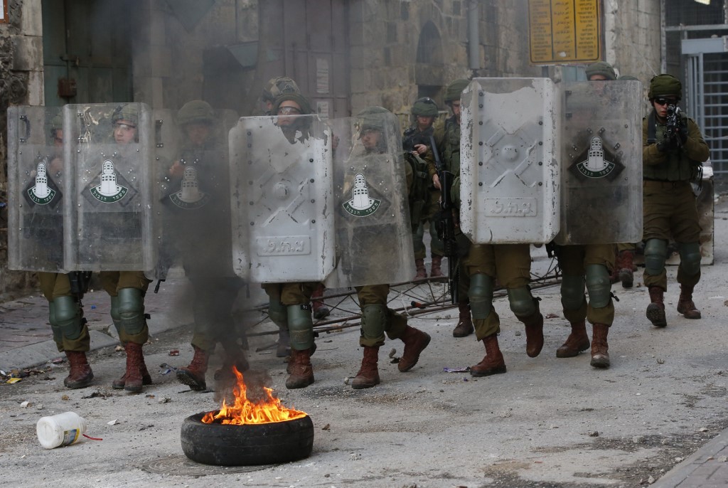 Israeli troops move through Hebron in the occupied West Bank on 30 January (AFP)