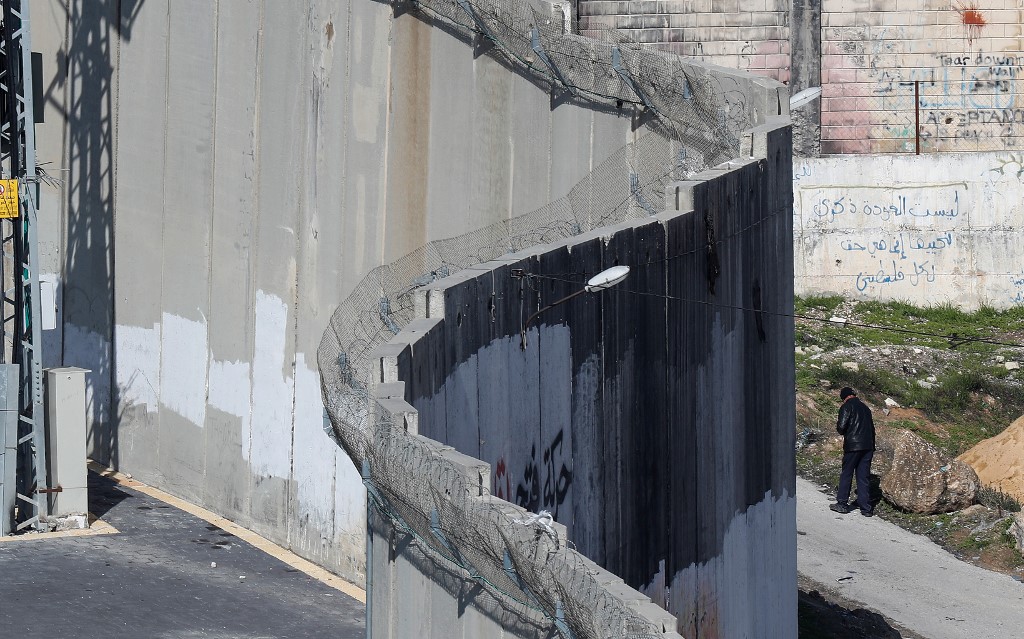 A man walks along the wall dividing East Jerusalem from the Palestinian village of Abu Dis on 29 January (AFP)