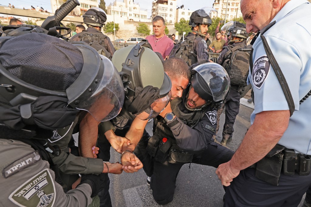 Israeli forces detain a Palestinian during a protest condemning Abu Akleh’s death in occupied East Jerusalem on 11 May 2022 (AFP)