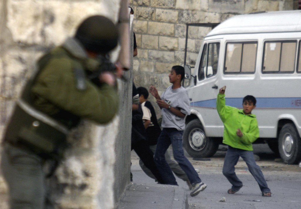 An Israeli soldier aims towards Palestinian children during clashes in occupied East Jerusalem in November 2000 (AFP)