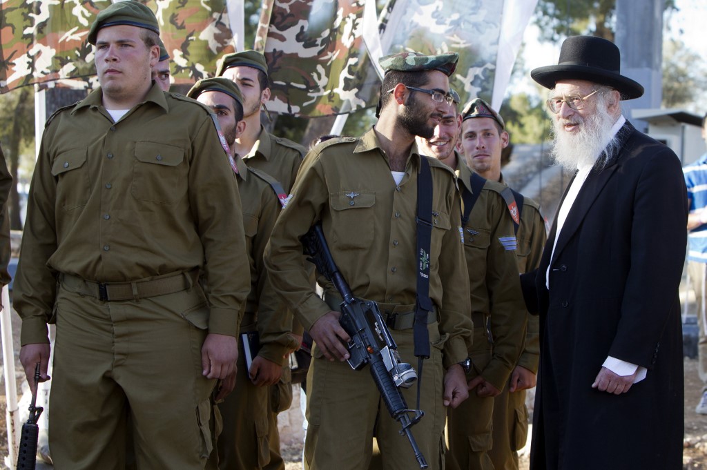 A rabbi speaks to a soldier with the Ultra-Orthodox 'Netzah Yehuda' Israeli army battalion at a swearing-in ceremony in Jerusalem (AFP)