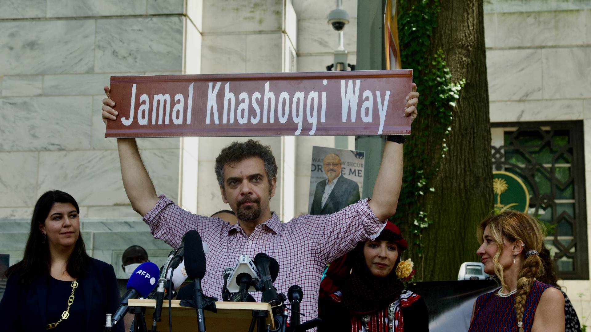 Raed Jarrar, advocacy director at Democracy for the Arab World Now, holds up the Jamal Khashoggi Way street sign