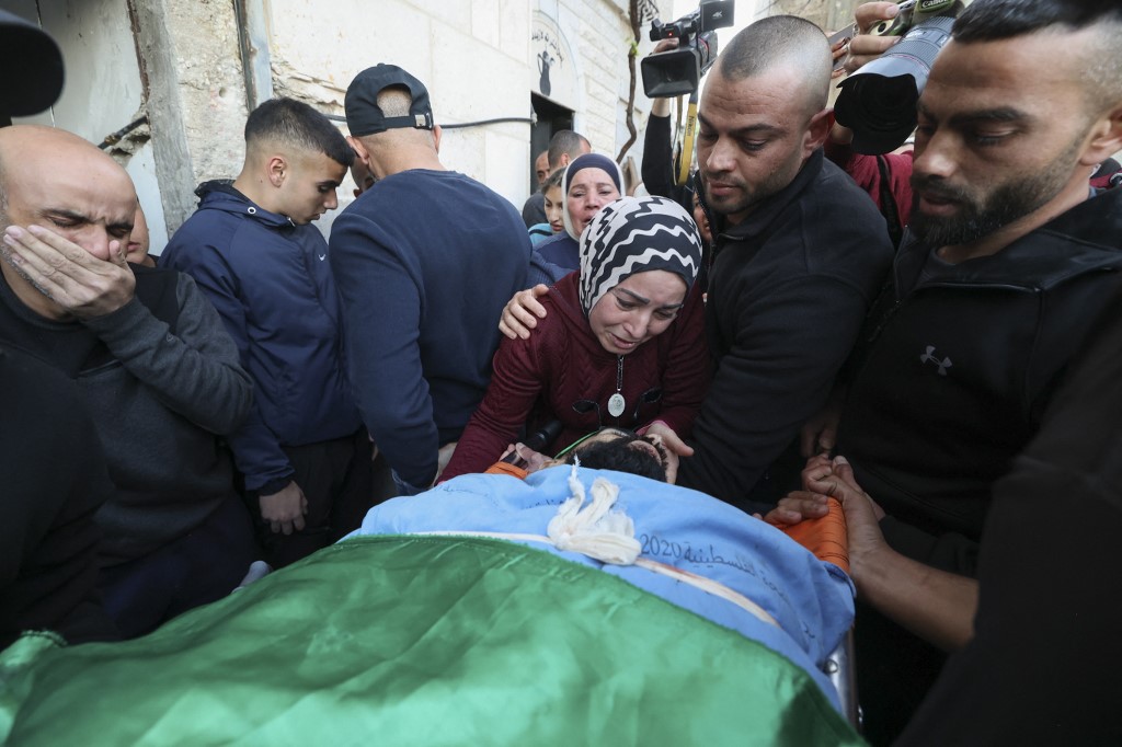 Des proches se recueillent devant les corps de Palestiniens tués lors d’un raid israélien plus tôt dans la journée, lors de leurs funérailles à Jénine (Cisjordanie occupée), le 16 mars 2023 (AFP)