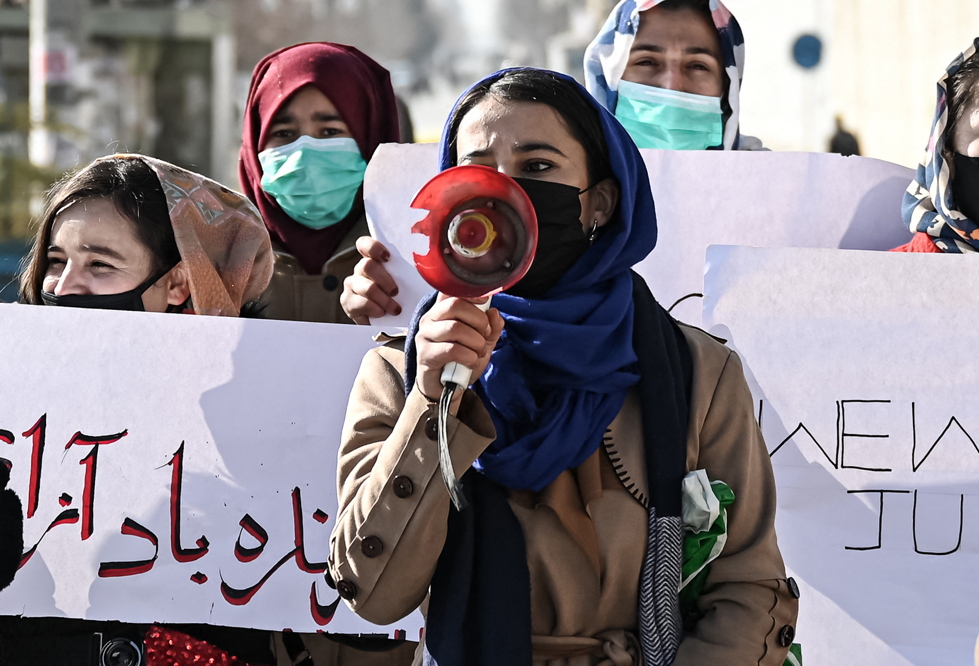 Women hold placards during a protest to demand an end to the extra-judicial killings of former officials of the previous regime, in Kabul on 28 December, 2021 (AFP)