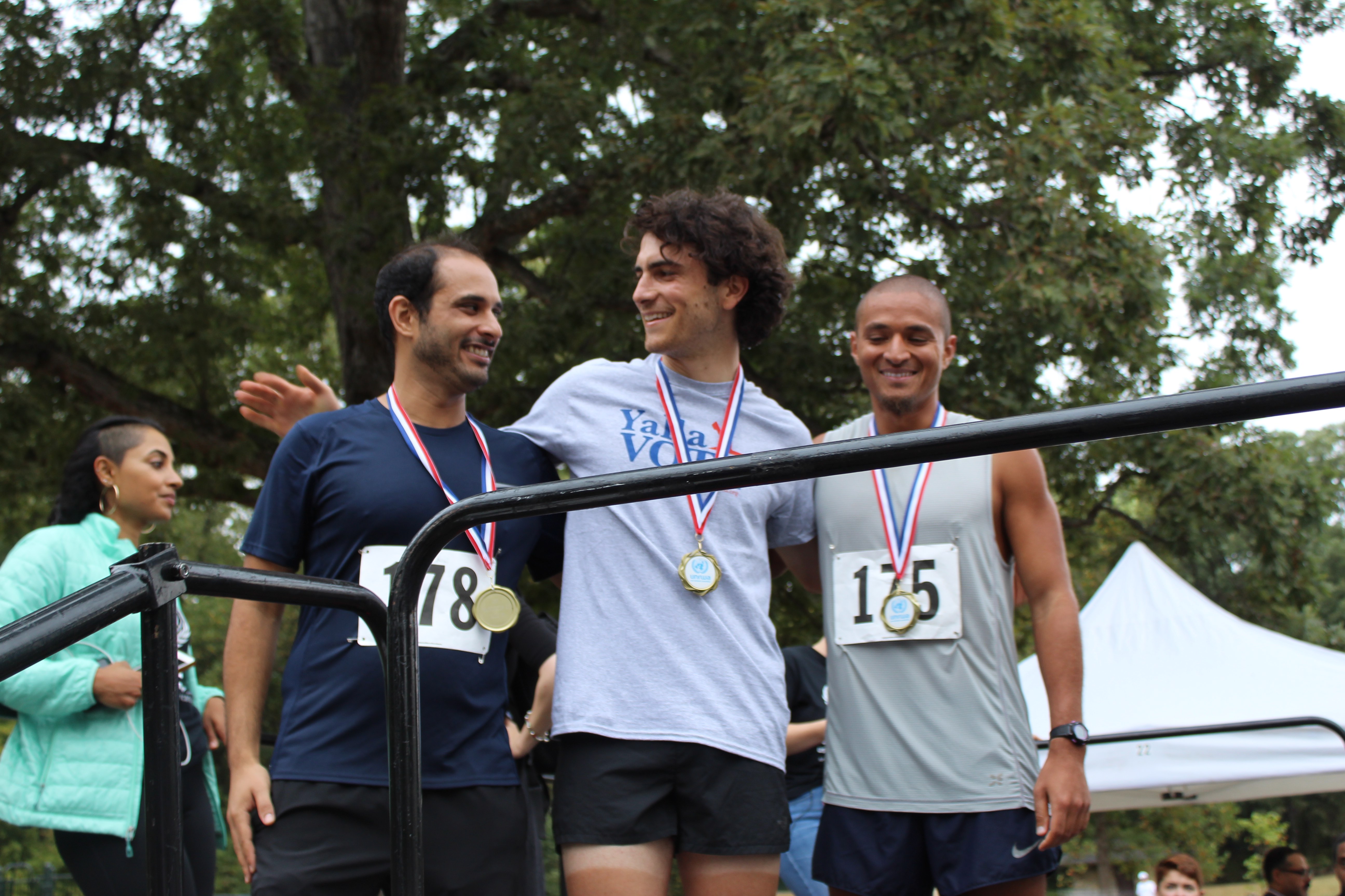Kai Wiggins standing between two other runners after accepting their medals at the Gaza 5k (MEE/Sheren Khalel) 