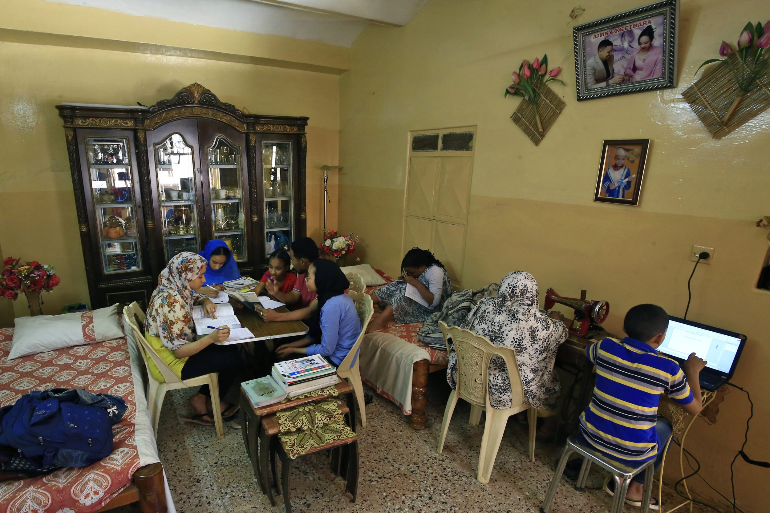 Members of a family study together at home in Khartoum on 23 March, as schools and universities close as a preventive measure against the spread of the Covid-19 virus (AFP)