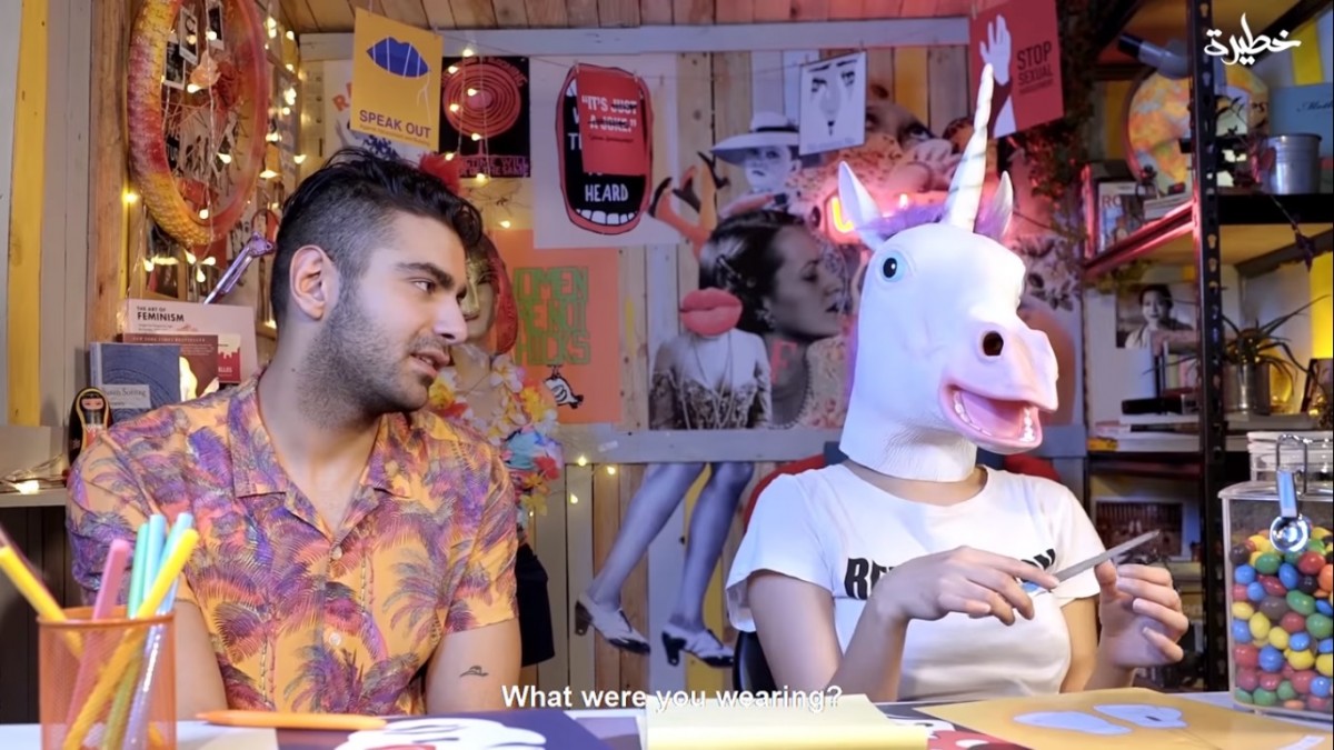 Maria, with a unicorn head, being questioned by her male co-presenter (screengrab)