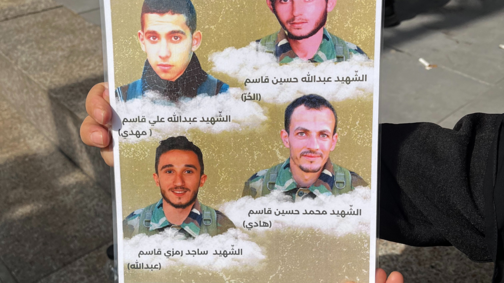 Zahraa Qassem holds the picture of her killed relatives, with Mohammad (bottom right) and Sajed (bottom right). The top two members were killed in previous battles (Nader Durgham/MEE)