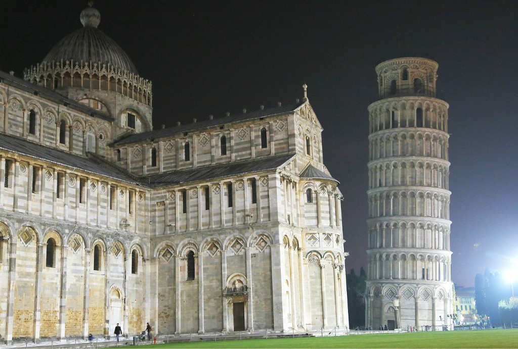 People walk past the leaning tower of Pisa and the cathedral at night on 16 March 2014 in Pisa (Fabio Muzzi/AFP)