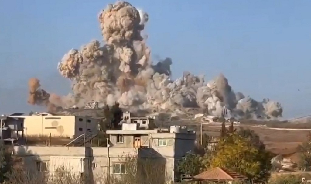 An image grab taken from a UGC video posted on social media on October 16, 2024, shows soldiers observing massive explosions in the village of Mhaibib in southern Lebanon, amid the ongoing war between Israel and Hezbollah.