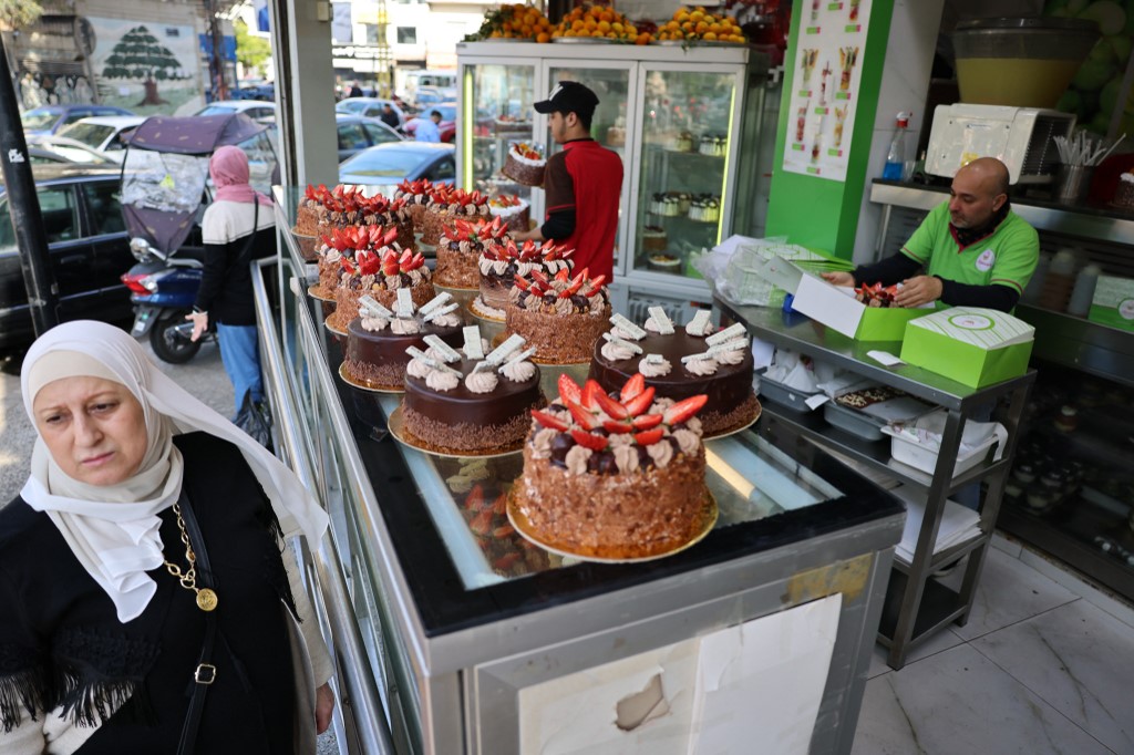 A woman walks past cakes displayed outside a sweets shop at two million Lebanese pounds each (about 20 US dollars) on Mother's Day in the southern suburbs of Beirut on March 21, 2023, 