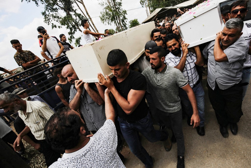 Men carry the coffins of victims of a fuel tank explosion that occurred last week in Al-Tleil in Lebanon's Akkar region, during the funeral of four members of the Shteiteh family in the village of al-Daouseh, in August 18, 2021.