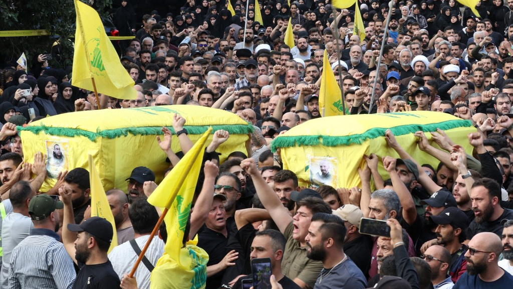 Mourners attend the funeral of two Hezbollah members in the southern village of Khirbet Silem, Lebanon, on 10 October 2023 (AFP)