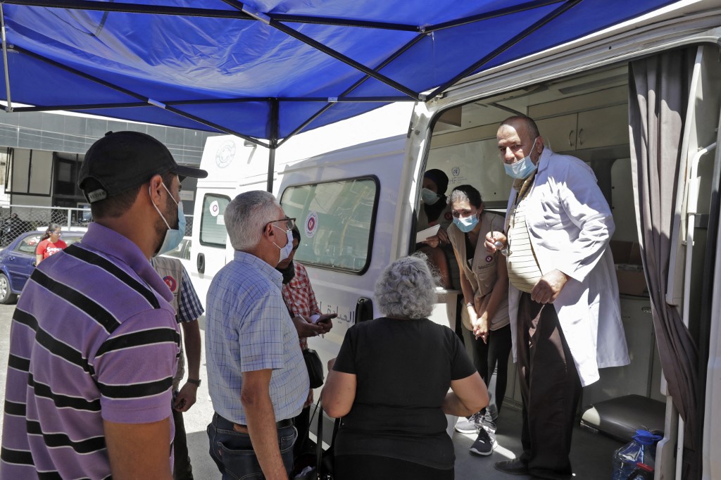Des médecins dans une clinique mobile détenue par l’ONG libanaise Amel et Médecins du Monde prodiguent des soins le 11 août 2020 aux habitants du quartier de Karantina (AFPAnwar Amro)