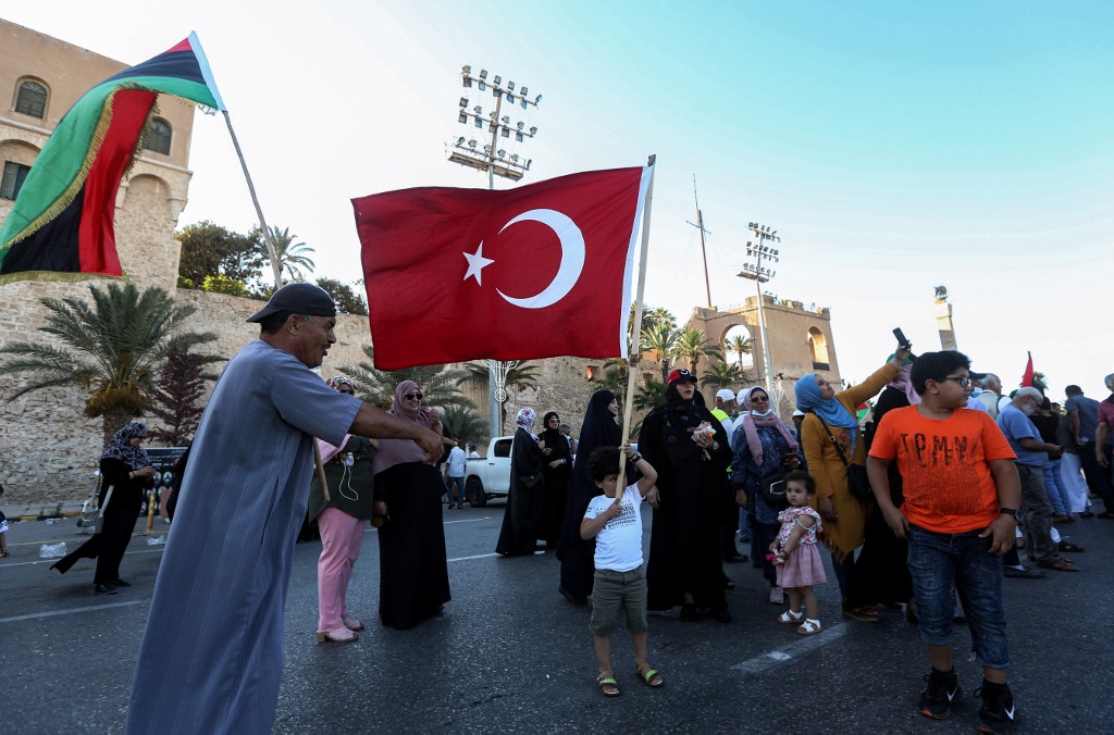 People wave Libyan and Turkish flags during a demonstration in Tripoli on 21 June (AFP)